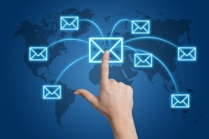 Communication concept Communication concept: Hand pressing a letter icon on a world map interface