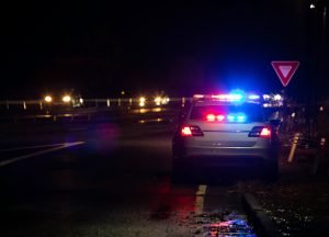 A picture containing cop pullover at night