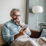 white bearded old guy looking at phone