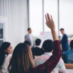 woman raising her hand with a question